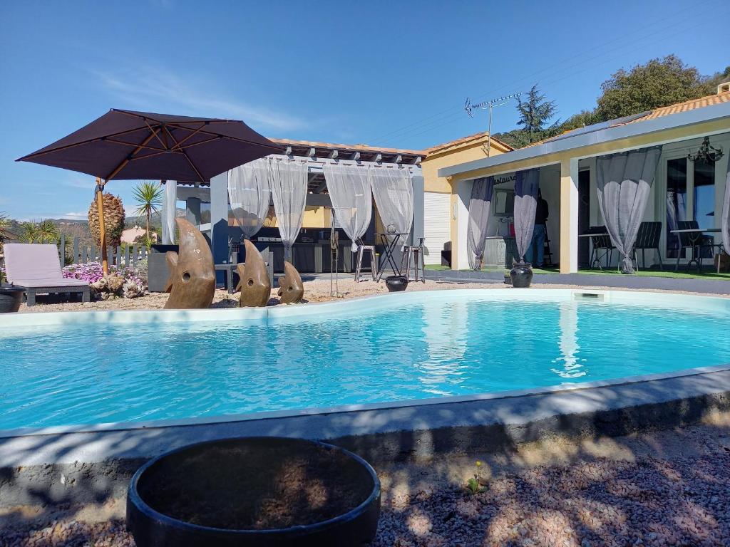 阿拉塔A Casa di Mariano的一个带遮阳伞和椅子的游泳池以及一座房子