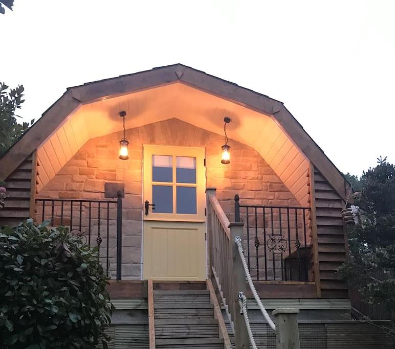 普里茅斯Bumble Bee Cottage的小木屋设有黄色门和楼梯