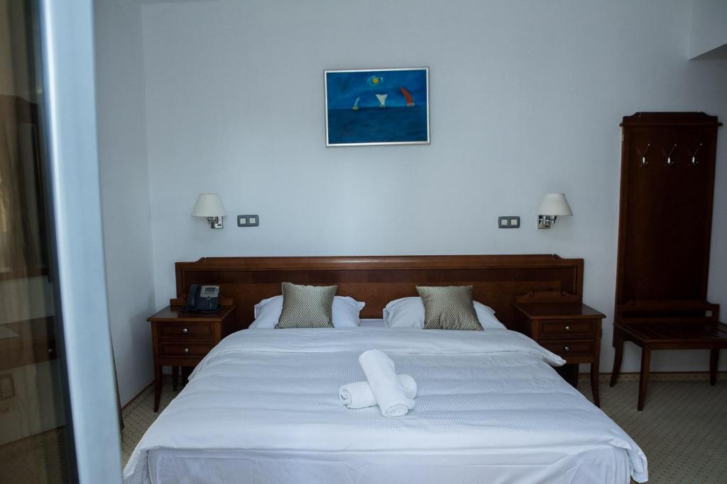 柳布什基哈姆酒店的一间卧室配有一张带两条白色毛巾的床