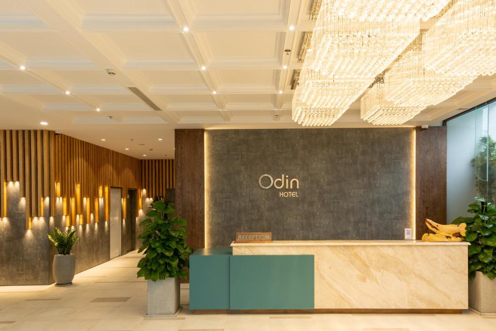 归仁Odin Hotel Quy Nhon的一个带前台和植物的办公大厅