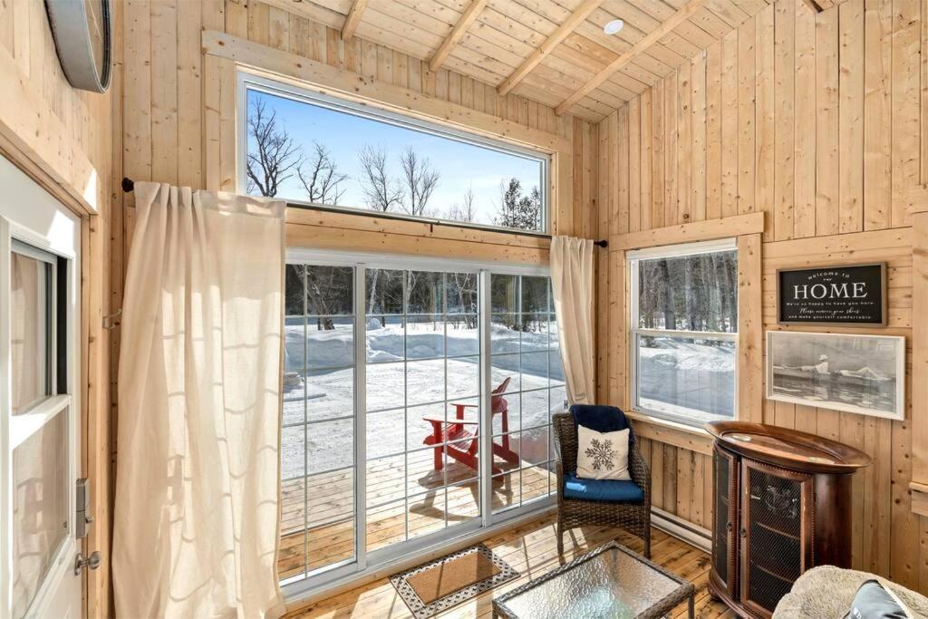 巴瑟斯特Cozy Cabin for Intimate Wilderness Escape的房屋内带大窗户的房间