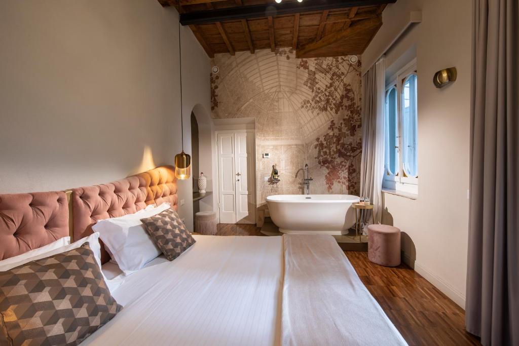 佛罗伦萨Ricasoli Garden Relais的一间卧室设有一张大床和一个水槽