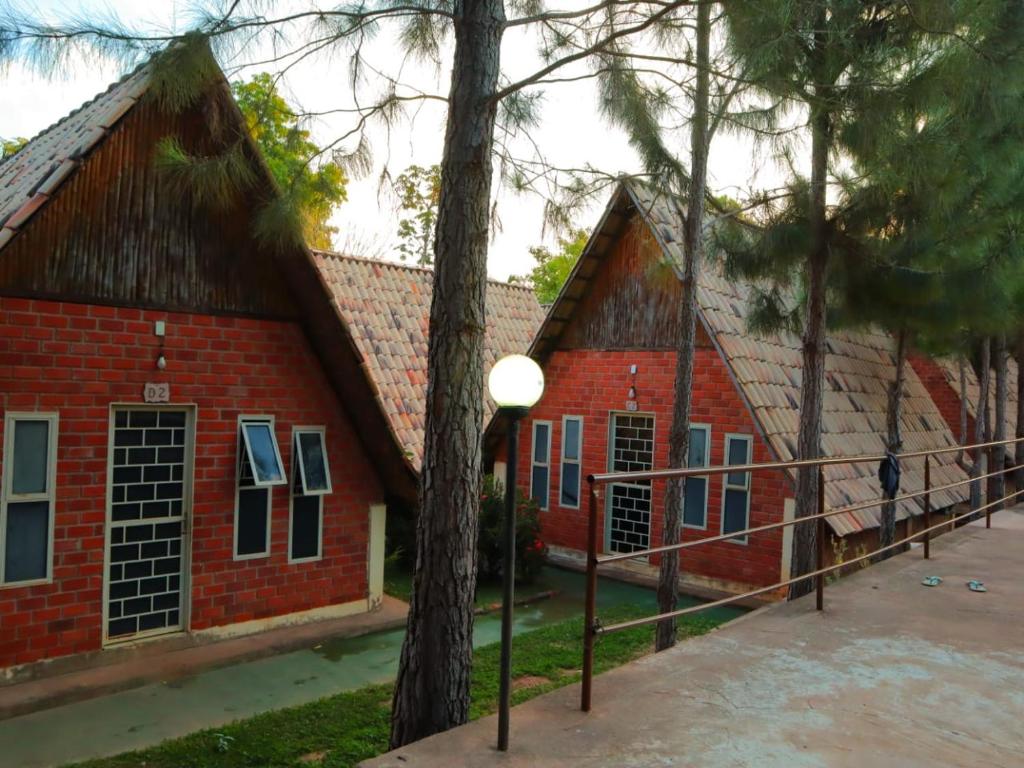 托坎廷斯州蓬蒂阿尔塔Pousada Vereda das Aguas的前面有树木的红砖建筑
