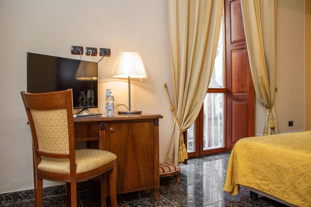 那不勒斯乐德尔精品酒店的一间卧室配有一张床和一张书桌及电视