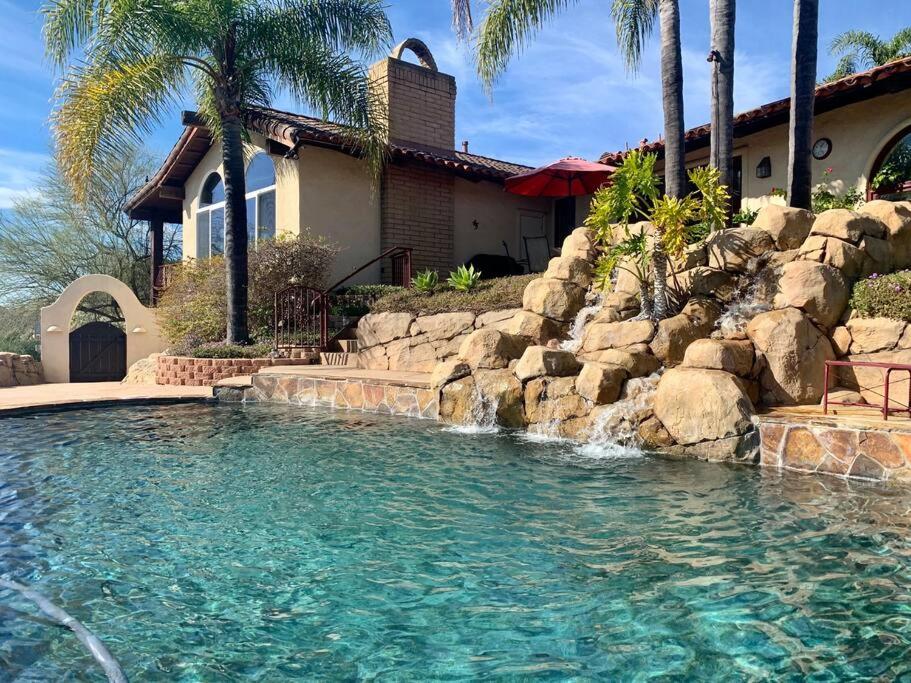 埃斯孔迪多Hilltop Hacienda - Views - Pool的一座带游泳池和岩石墙的房子