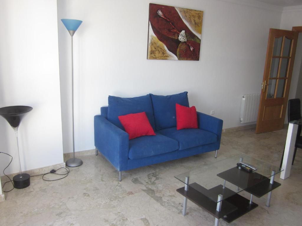 瓜迪克斯Apartamento ideal的客厅里配有带两个红色枕头的蓝色沙发