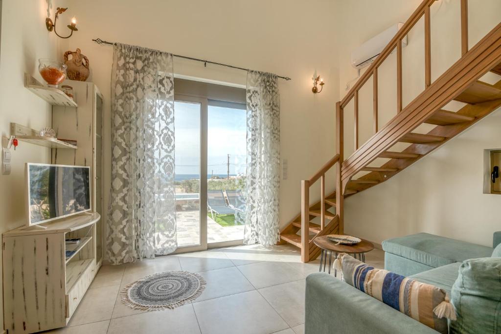 Agios PadeleimonPink Sand Villas的客厅设有蓝色的沙发和滑动玻璃门