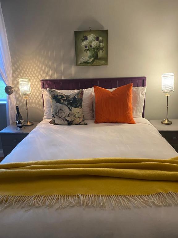 Ballydavid利艾斯卡住宿加早餐旅馆的一间卧室配有一张带橙色枕头的大床