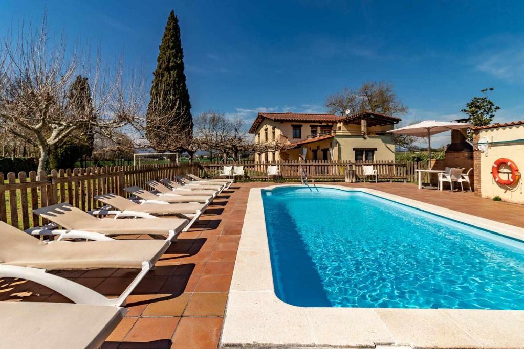 赫罗纳Can Salvà Casa rural en magnífico entorno natural的一个带躺椅的游泳池以及一座房子