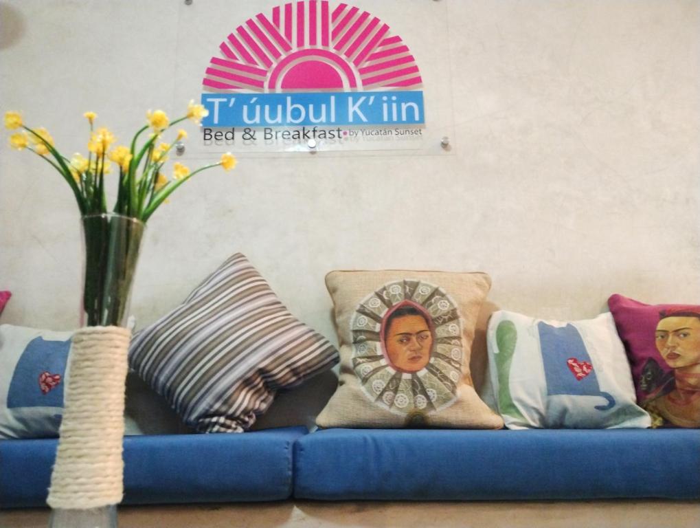 梅里达T´úubul K´iin Bed & Breakfast的蓝色的沙发、枕头和花瓶