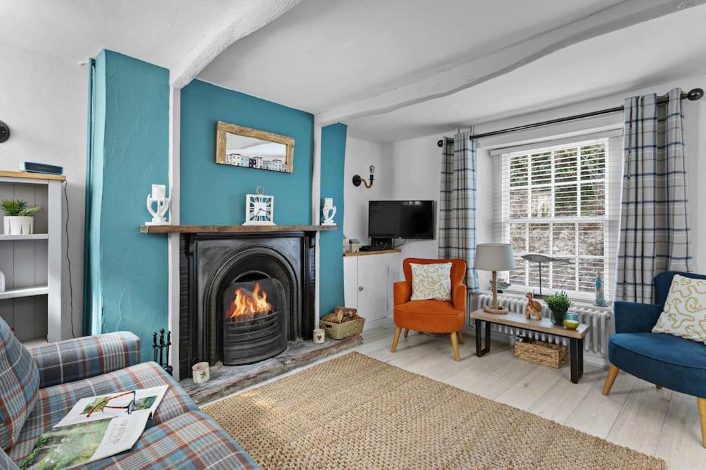 布里克瑟姆Family Tides Brixham的客厅设有壁炉和蓝色的墙壁。