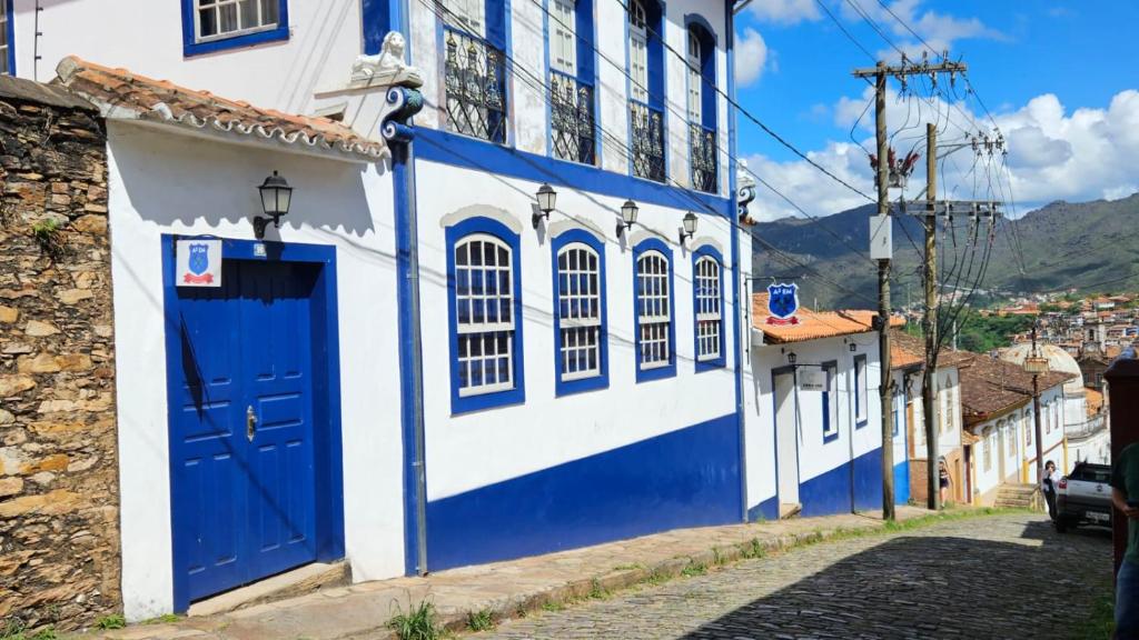 欧鲁普雷图A3EM Casa de Gorceix的蓝色和白色的建筑,设有蓝色的门