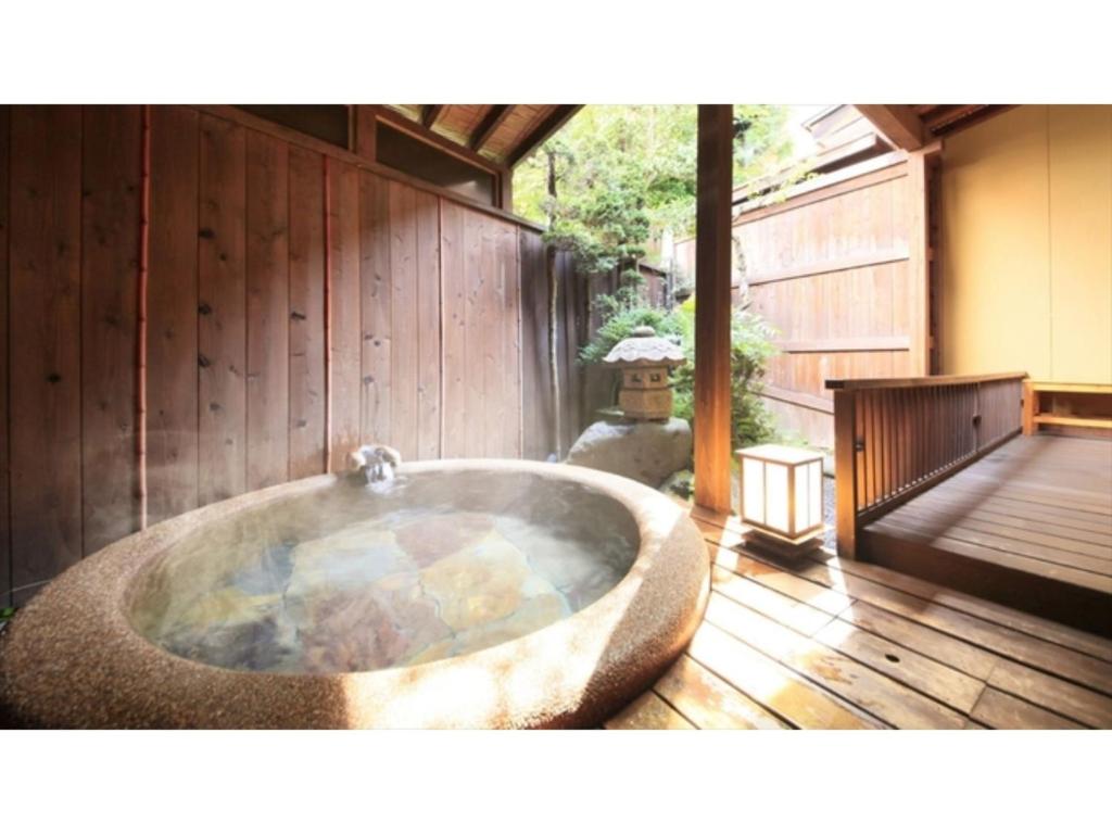 上山市Saikatei Jidaiya - Vacation STAY 96452v的木制甲板上的大型浴缸