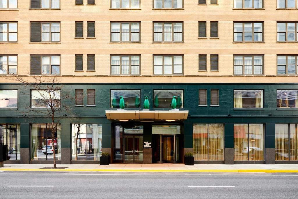 芝加哥21c Museum Hotel Chicago的前面有绿色座椅的大型砖砌建筑