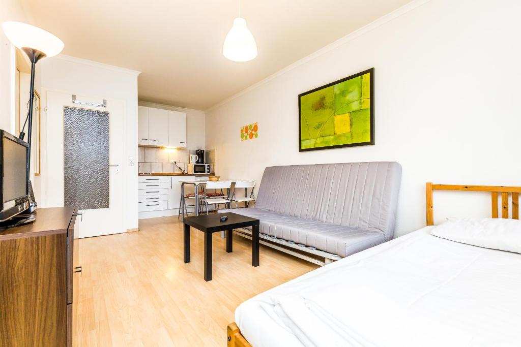 科隆Work and Stay Koeln Ostheim的客房设有床、沙发和桌子。