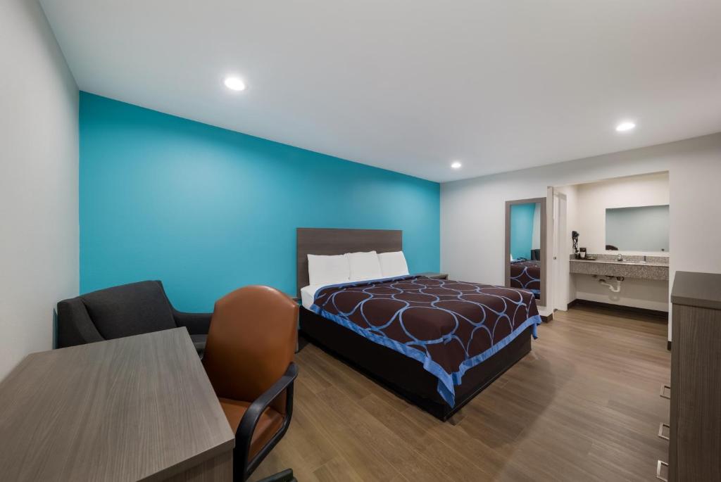 威奇托福尔斯威奇托福尔斯豪生汽车旅馆的一间卧室设有一张床和蓝色的墙壁