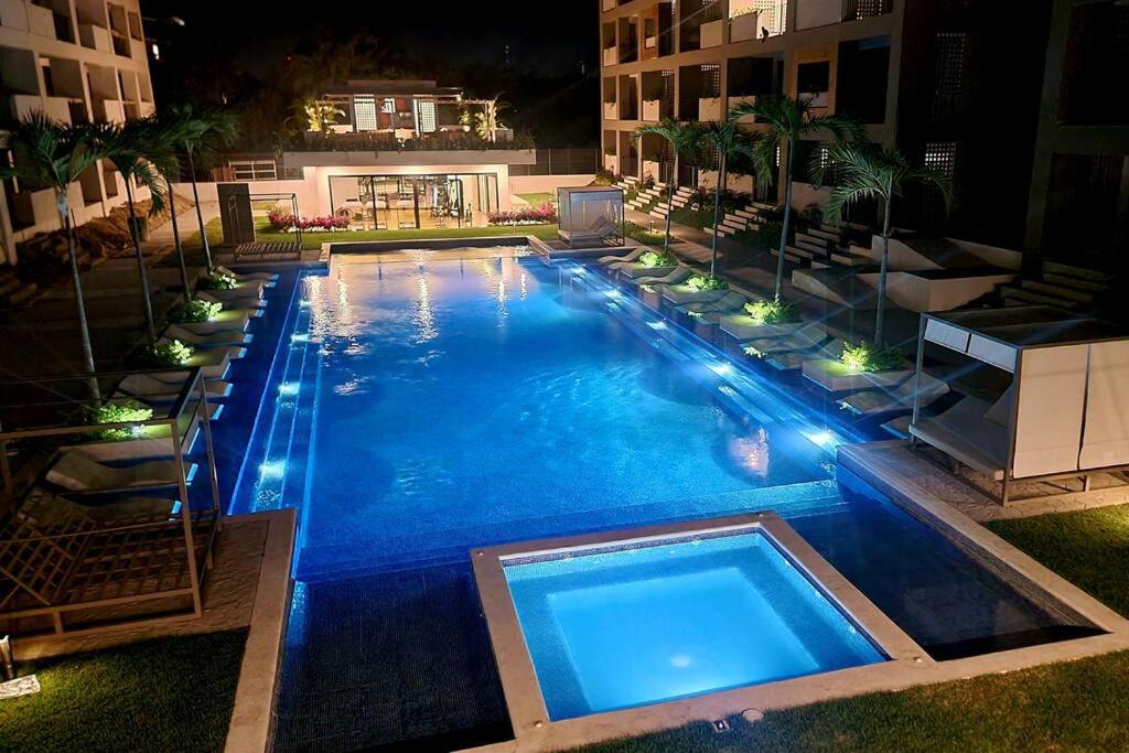 新巴利亚塔IYARI 2 bdr Apartment的夜间蓝色海水的大型游泳池