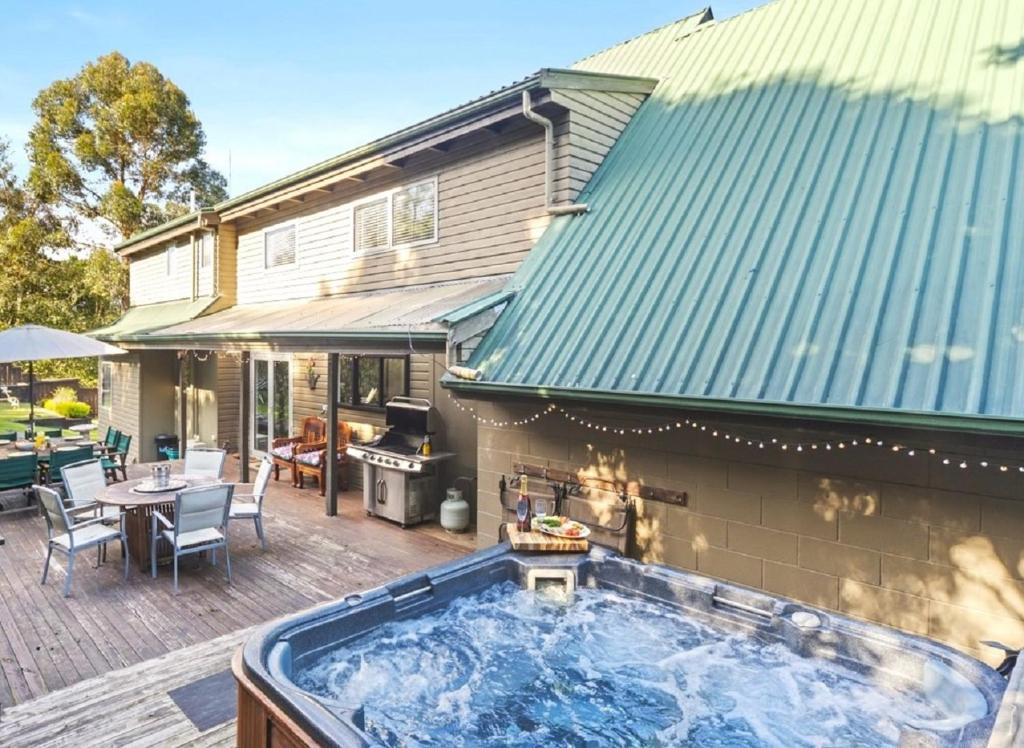 陶波Botanical HideAway Taupo的房屋旁甲板上的热水浴池