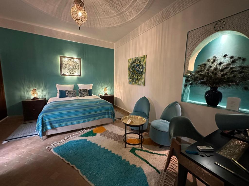 马拉喀什La Claire Fontaine的卧室配有一张床和一张桌子及椅子