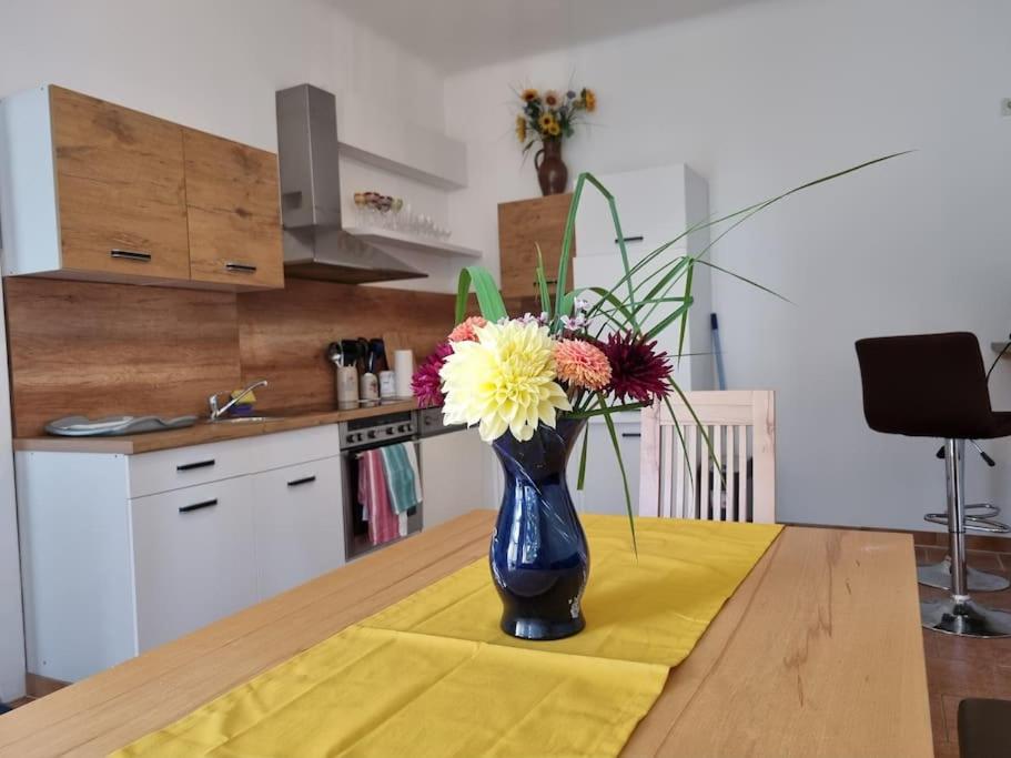 特赖斯基兴Ferienhaus für Familien und Hundeliebhaber的花朵盛在桌子上的蓝色花瓶