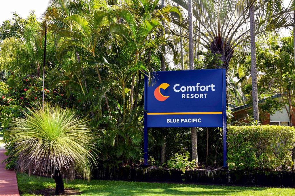 麦凯Comfort Resort Blue Pacific的树木前的舒适度假村标志