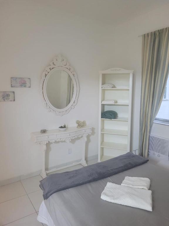 里约热内卢Lindo Apartamento Flamengo的白色卧室配有床和镜子