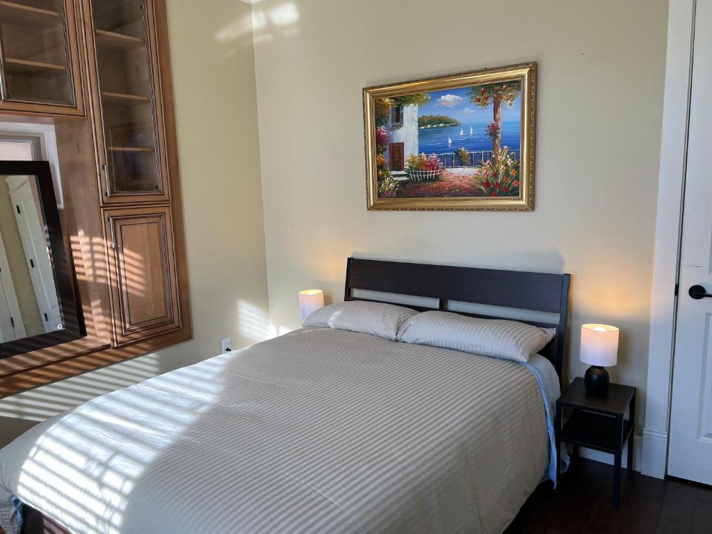 温哥华Mike's Luxury House的卧室配有一张床,墙上挂有绘画作品