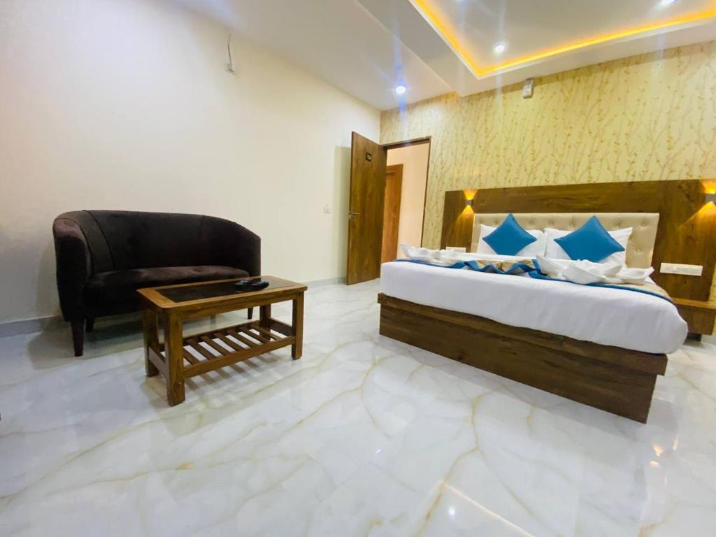 班加罗尔Spectra Hotel Bangalore Airport的一间卧室配有一张床、一把椅子和一张桌子