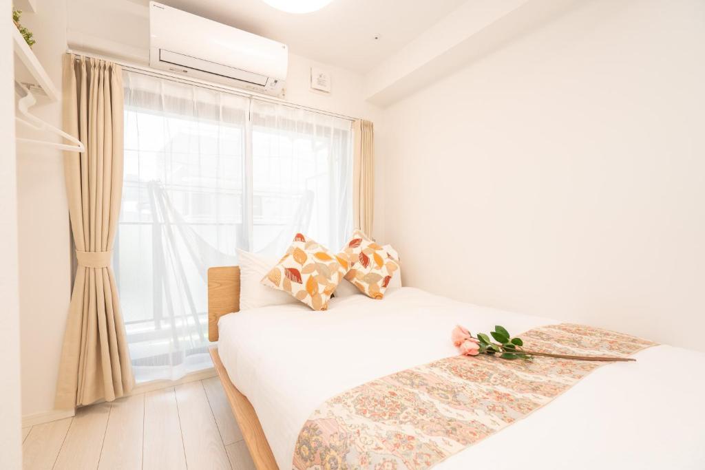 东京リアル大久保　Apartment Hotel的白色的卧室设有床和窗户