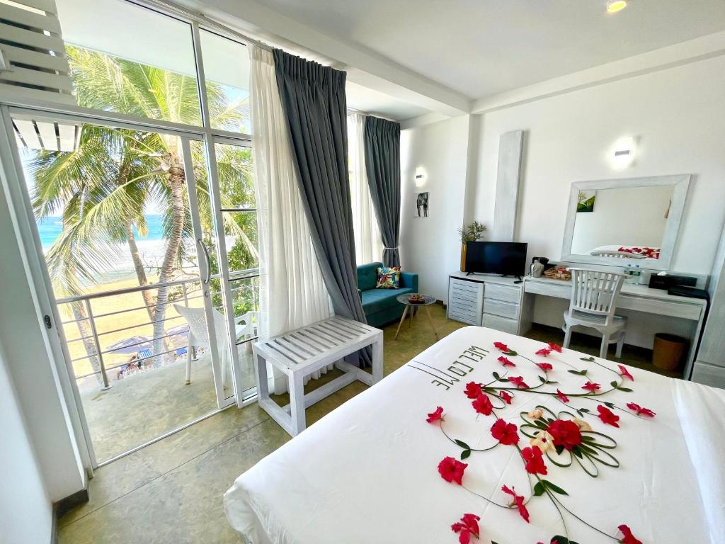 迪克韦勒Smeralda Beach Hotel Dikwella的一间卧室,床上有红色的鲜花