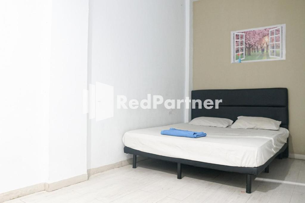 雅加达Cosmo Harmoni RedPartner的一张位于带白色床垫的房间内的床铺