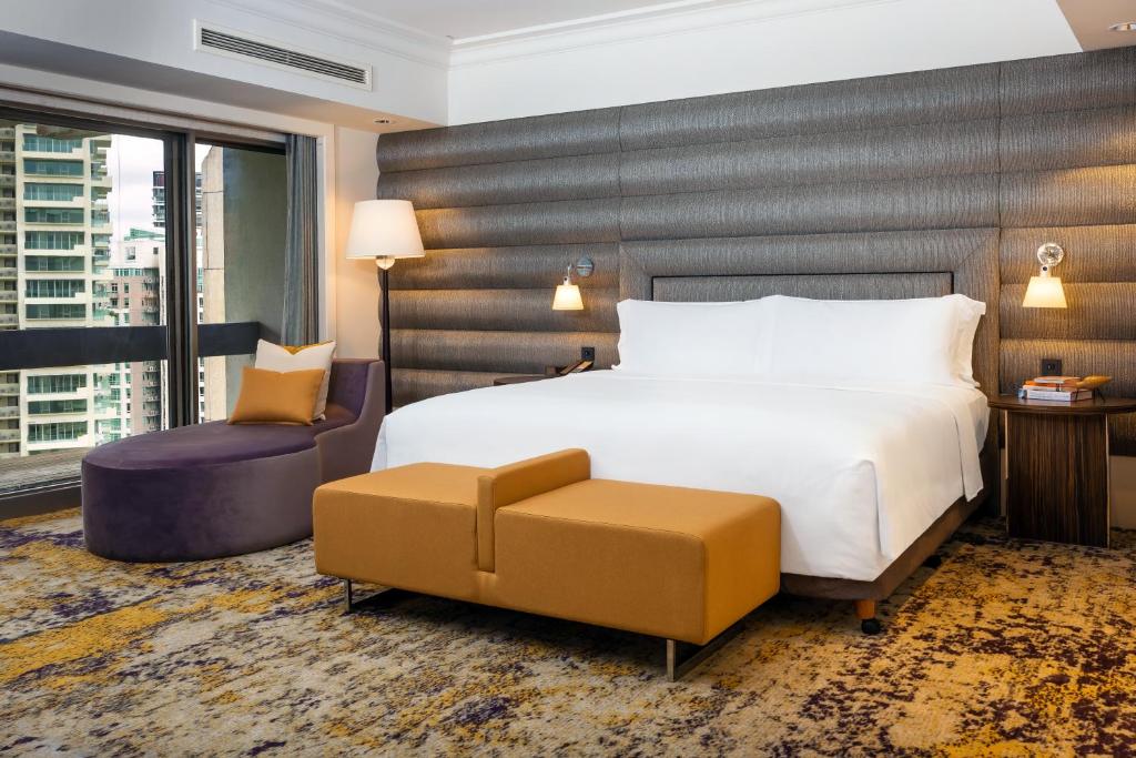 新加坡voco Orchard Singapore, an IHG Hotel的配有一张床和一把椅子的酒店客房
