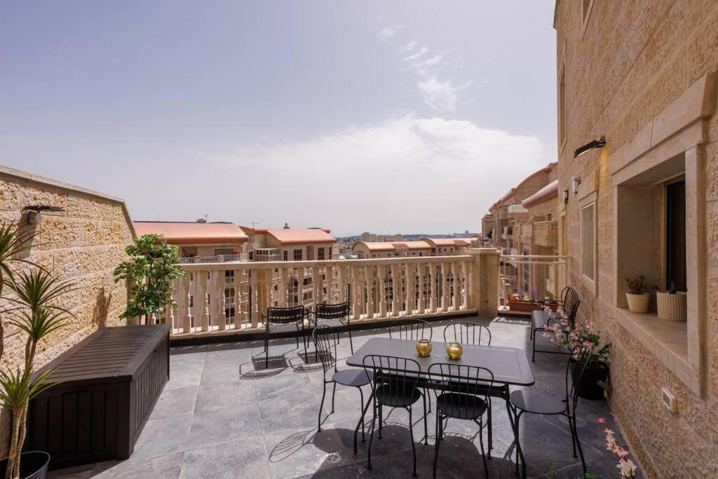 耶路撒冷Grand Jerusalem Luxury Apartment By Nimizz的阳台的天井配有桌椅
