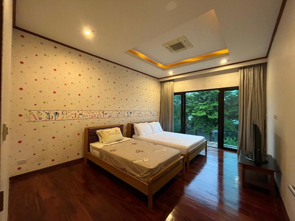 曼谷AP HOUSE的一间卧室设有两张床,墙上设有波卡点