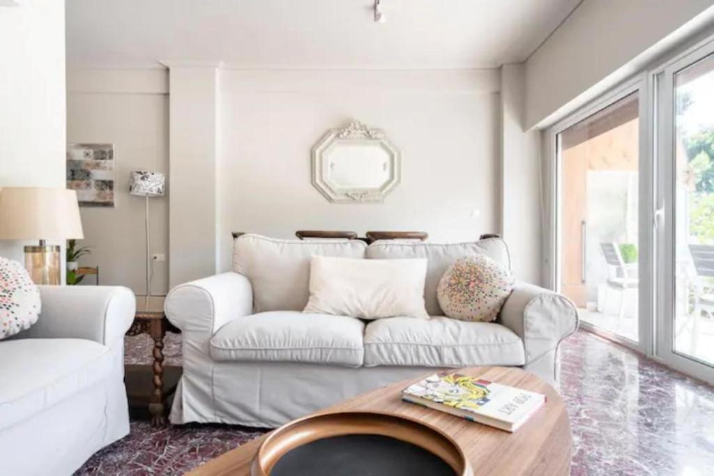 雅典Flisvos Marina refurbished apartment的客厅配有白色的沙发和桌子