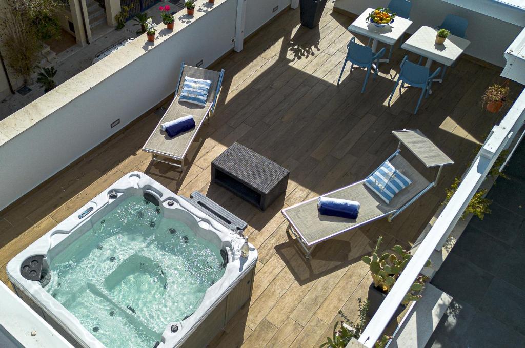 圣维托罗卡波Acquarò Suite Jacuzzi的阳台的热水浴池,配有桌椅