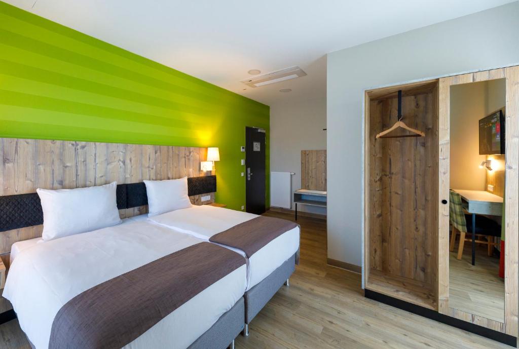 帕彭堡帕彭堡科迪酒店的一间卧室配有一张绿色墙床