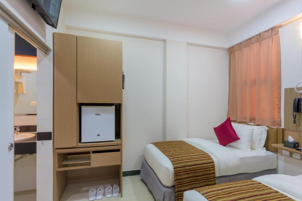 马累Beehive Central的酒店客房设有两张床和一台平面电视。
