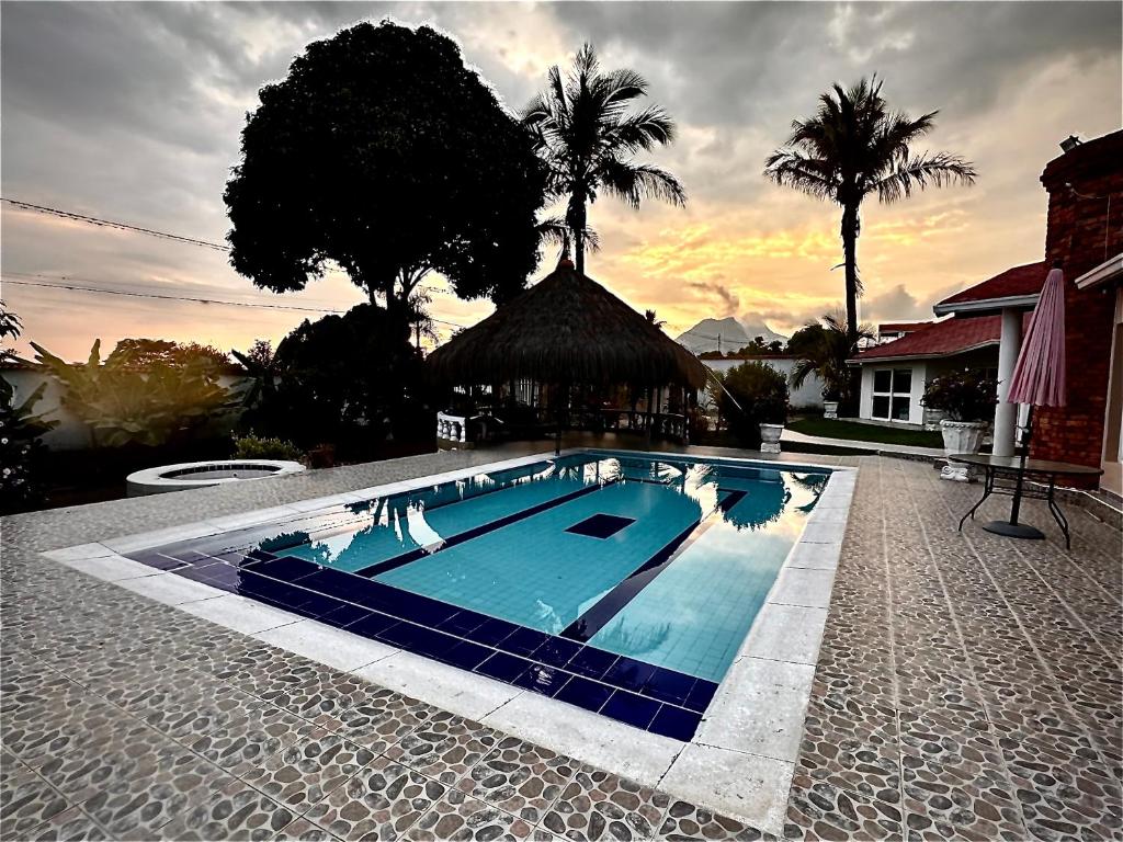 富萨加苏加El Bongo de Chinauta的棕榈树庭院里的一个大型蓝色游泳池