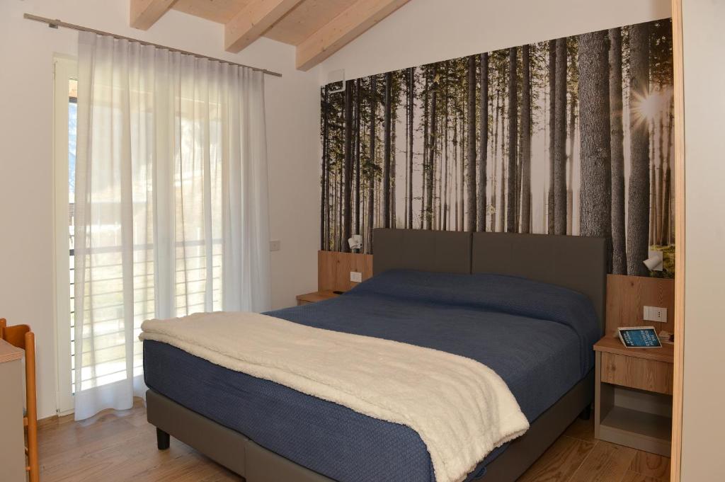 Nave San RoccoBed and Breakfast NAVIS的卧室配有床,墙上有树木