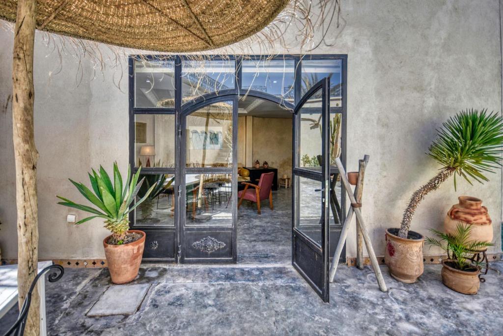 阿加迪尔Riad Amazine - Piscine - Rooftop - 6 or 7 Px的一间房间里一扇带盆栽的开放式门