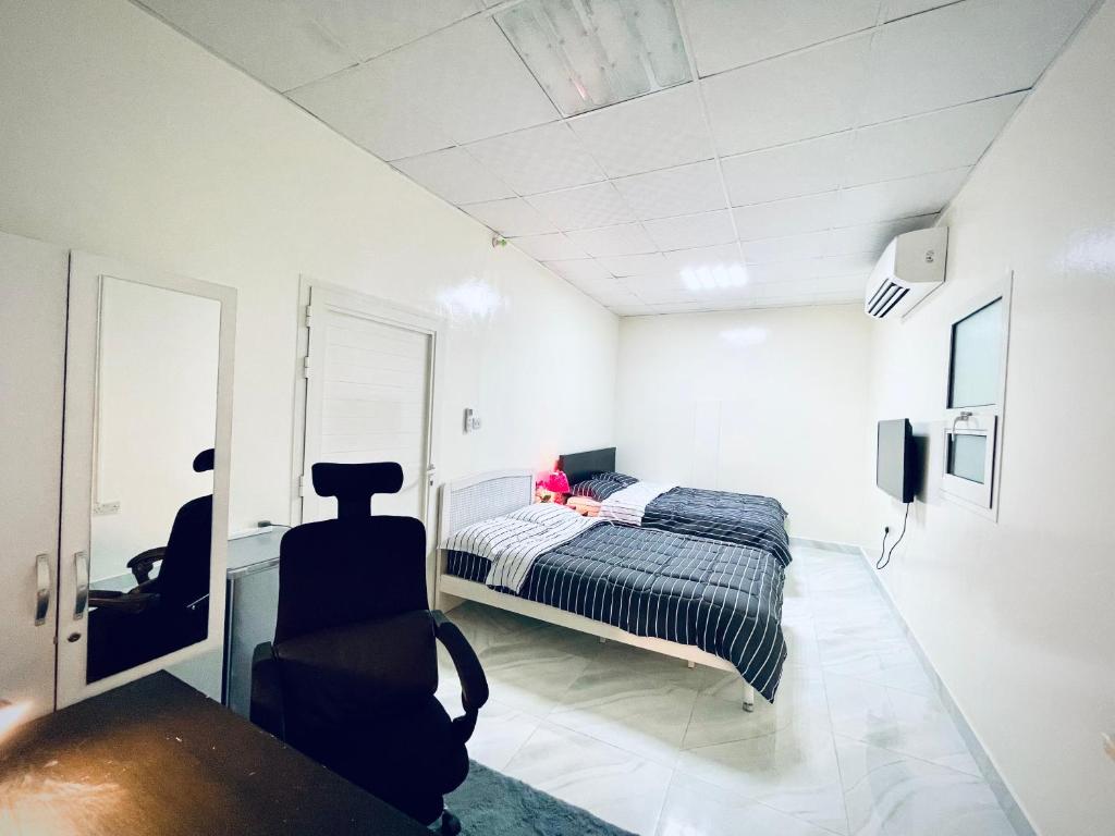 阿布扎比Private 2Bedroom Villa with T&B and Kitchenette near Abu Dhabi International Airport的一间卧室,配有一张床,女孩坐在床上