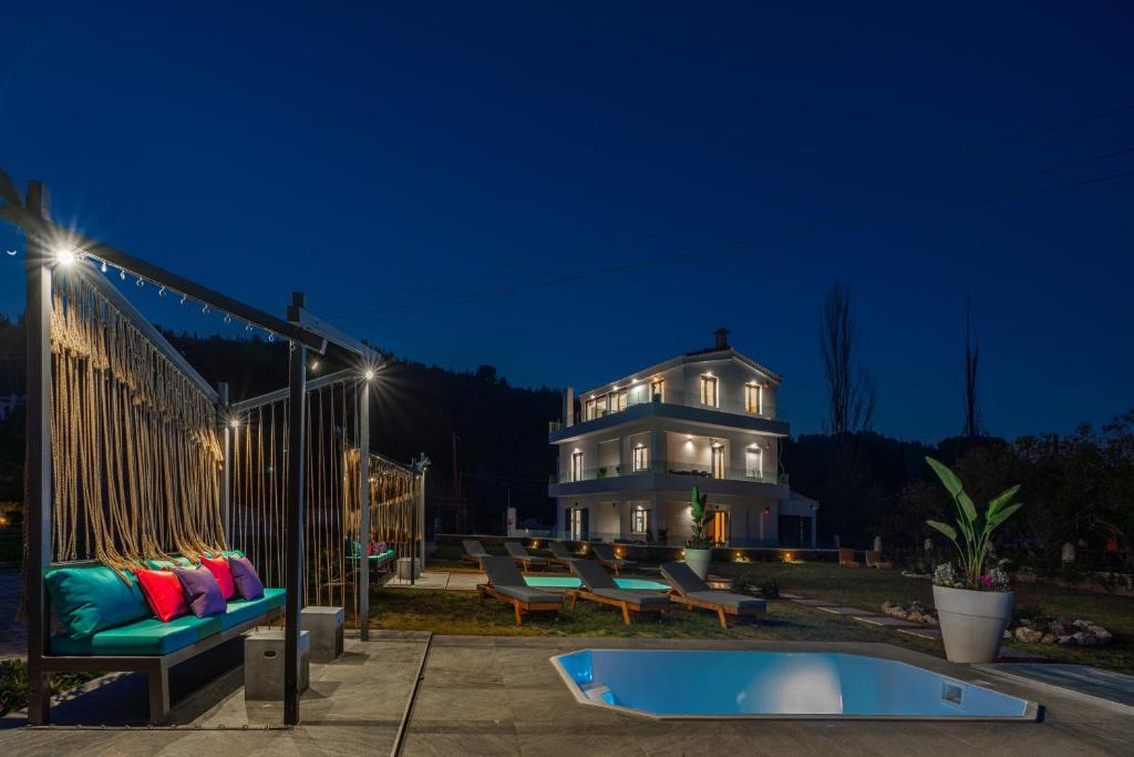 特劳洛斯Mythos Luxury Villa-Skiathos的一座房子,在晚上前设有一个游泳池