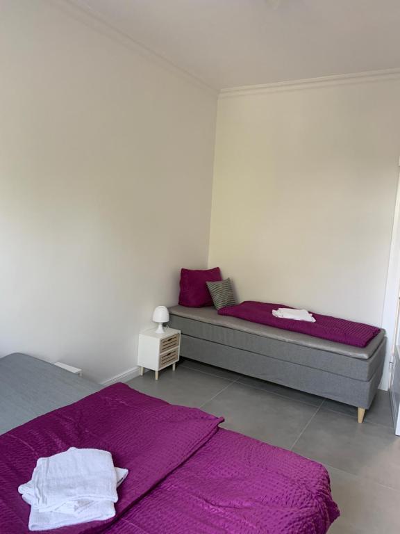 桑德Villa Mariensiel的一间卧室配有两张床和紫色床单