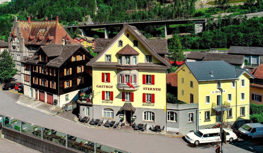 古尔特纳伦Hotel Sternen的一座黄色建筑,在镇上装有红色窗户