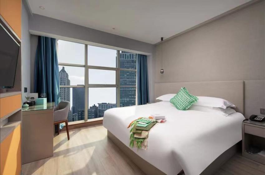 义乌Yiwu Manting Hotel International Trade City义乌漫庭酒店的卧室设有一张白色大床和大窗户