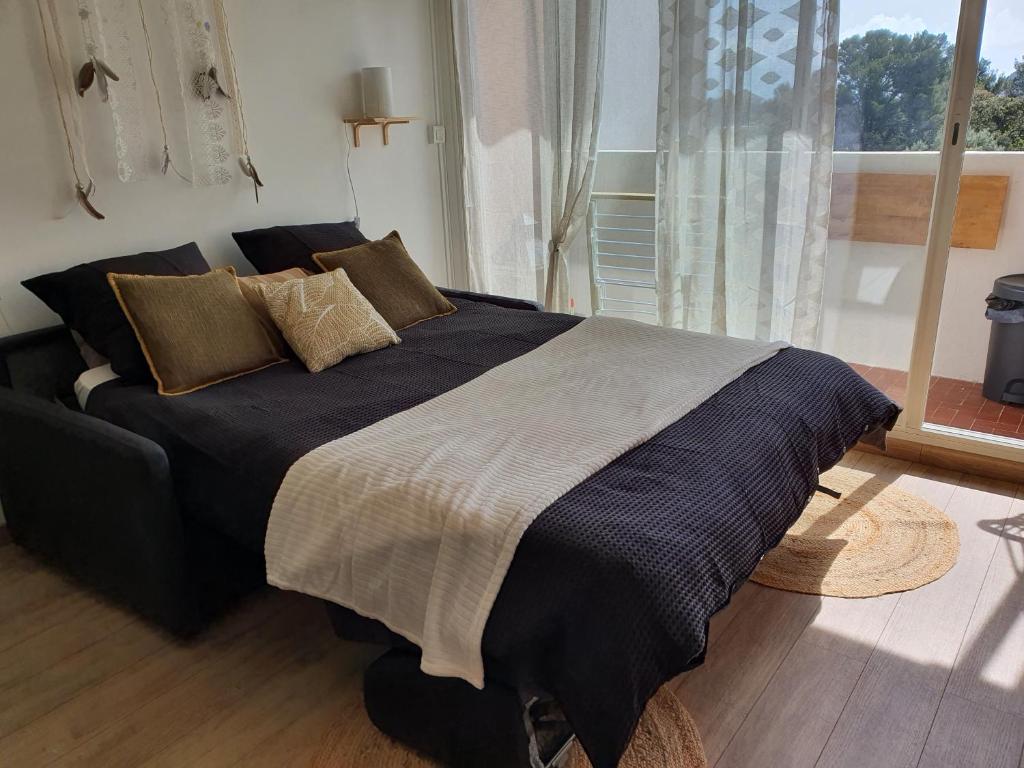 滨海卡瓦莱尔Joli Studio cavalaire的卧室内的一张大床,设有窗户