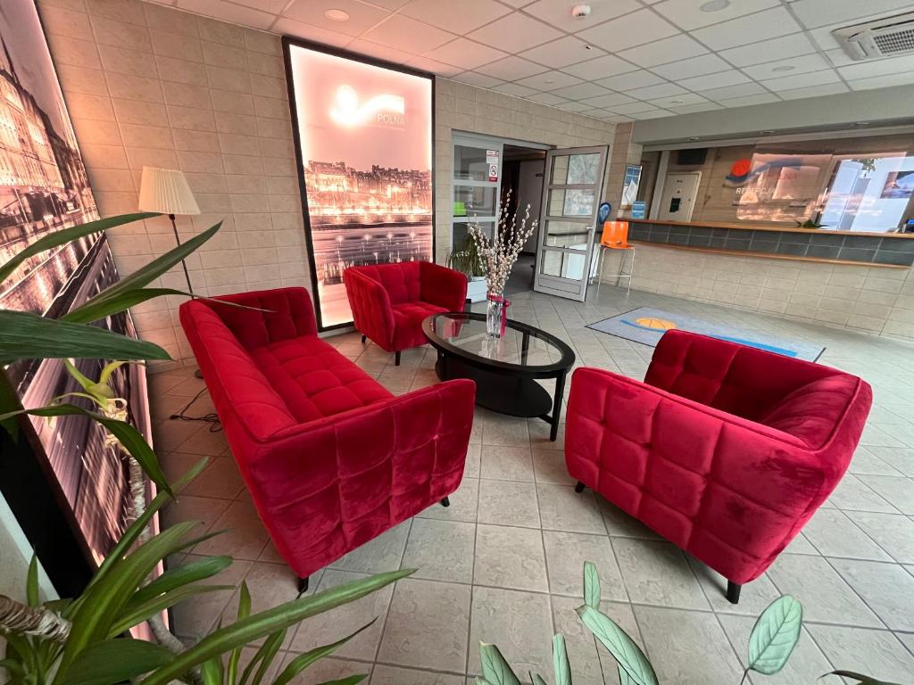 华沙斯洛德米斯切酒店的一间设有红色椅子和桌子的等候室