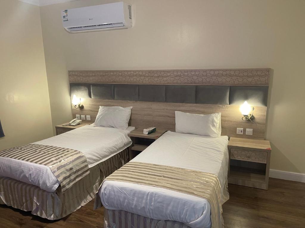 Ash Shishahفندق نزهة النسيم的酒店客房配有两张床和一张书桌