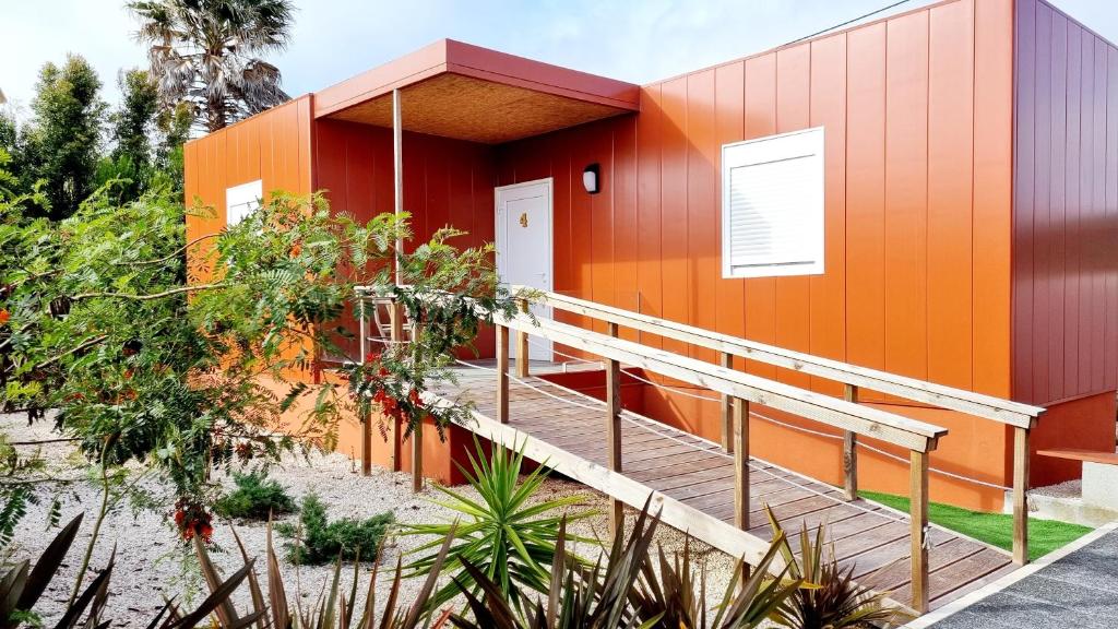 马夫拉Family Surf Home - Bungalows的一座橙色的建筑,旁边设有斜坡